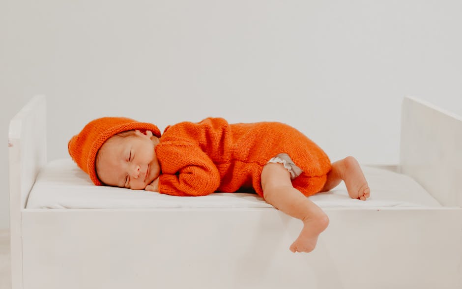Babykleidung und Erstausstattung auf dem Bett ausgebreitet
